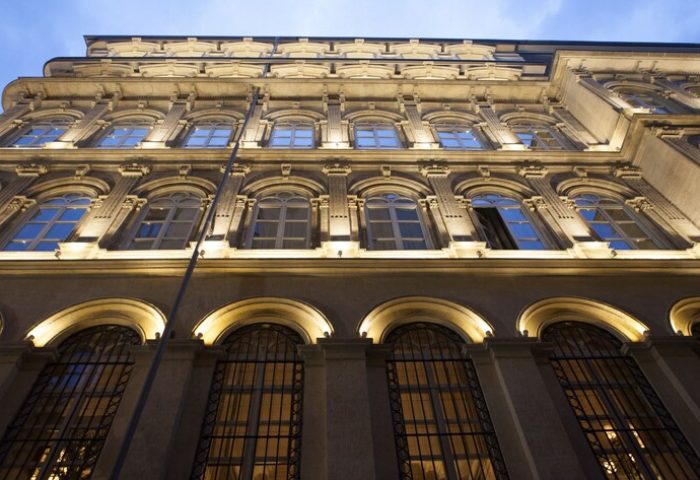 Facade of The Bank Hotel Istanbul, a Design Hotel. Arched windows with iron bars. Gay-friendly hotel architecture. Night view.