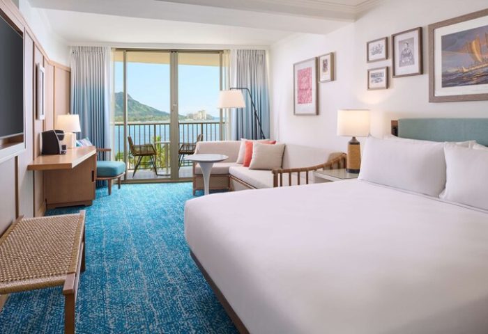 Outrigger Reef Waikiki Beach Resort gay-friendly hotel room with balcony and ocean view. Modern design, comfortable bed, and inviting decor.