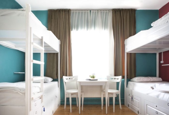 Cheers Midtown Hostel gay-friendly hotel room. Bunk beds, table, and chairs create a welcoming space for gay travelers. Interior design.