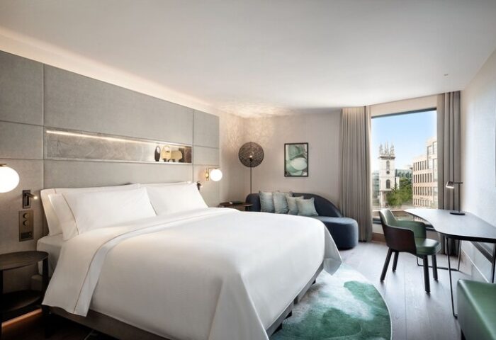 The Westin London City hotel room. Gay-friendly hotel with a king bed, chaise lounge, desk, and city view. Modern design for gay men travelers.