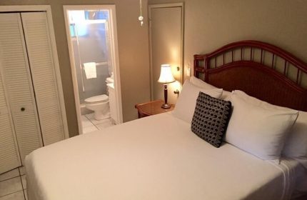 Coral Reef Guesthouse room. Gay-friendly hotel bedroom with a bed, pillows, closet, and bathroom. Gay travel accommodations.