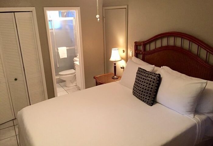 Coral Reef Guesthouse room. Gay-friendly hotel bedroom with a bed, pillows, closet, and bathroom. Gay travel accommodations.