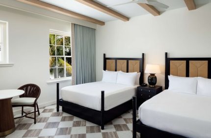 Casa Marina Key West, Curio Collection by Hilton: Gay-friendly hotel room with two beds, table, chair, and a view of palm trees.
