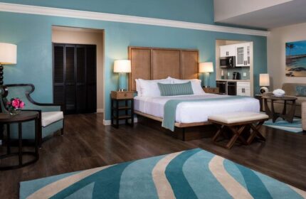 Opal Key Resort & Marina gay-friendly hotel room. King bed, kitchenette, sitting area, and blue accents create a relaxing, luxurious vacation space.