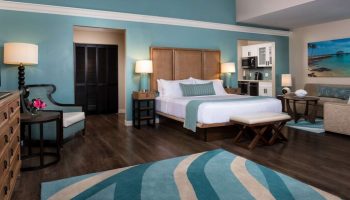 Opal Key Resort & Marina gay-friendly hotel room. King bed, kitchenette, sitting area, and blue accents create a relaxing, luxurious vacation space.