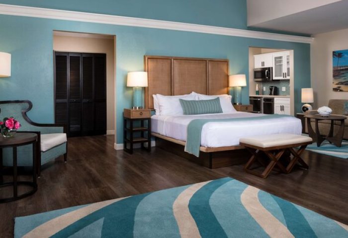 Opal Key Resort & Marina gay-friendly hotel room. King bed, kitchenette, sitting area, and blue accents create a relaxing, luxurious vacation space.