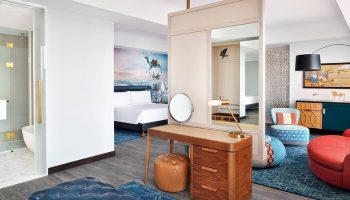 Hotel Indigo Dubai Downtown gay-friendly room. Modern design with desert mural, vanity, and colorful accents. Ideal for gay travel in Dubai.