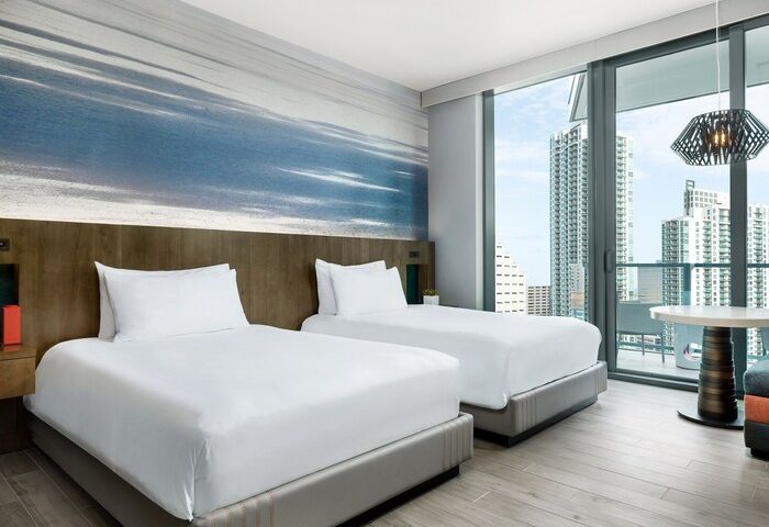 EAST Miami gay-friendly hotel room with two beds, modern decor, and a city view. Perfect for gay men's travel. Miami hotel room.