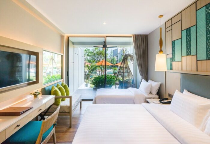 Avani+ Hua Hin Resort room. Gay-friendly hotel bedroom with twin beds, desk, TV, and outdoor view. Perfect for gay men's travel.
