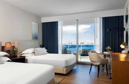 Kimpton EPIC Hotel gay-friendly room with two beds, desk, and balcony overlooking the ocean. Miami gay travel lodging option.