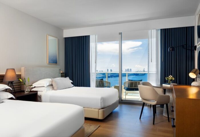 Kimpton EPIC Hotel gay-friendly room with two beds, desk, and balcony overlooking the ocean. Miami gay travel lodging option.