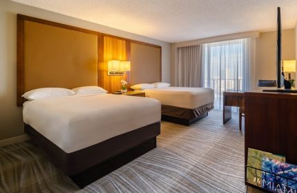 Hyatt Regency Miami gay-friendly hotel room with two beds, desk, TV, and balcony. A comfortable stay for LGBTQ+ travelers in Miami.