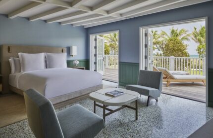 Four Seasons Hotel at The Surf Club gay-friendly hotel room. Balcony view, king bed, and modern decor. Luxury gay travel.