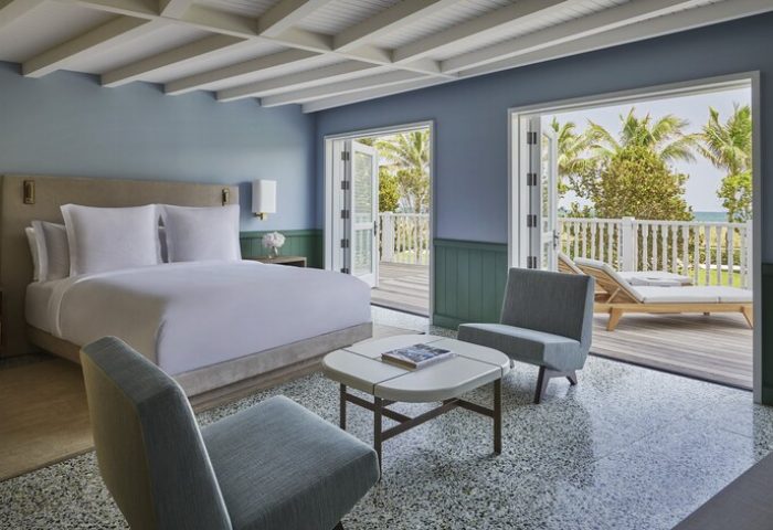 Four Seasons Hotel at The Surf Club gay-friendly hotel room. Balcony view, king bed, and modern decor. Luxury gay travel.