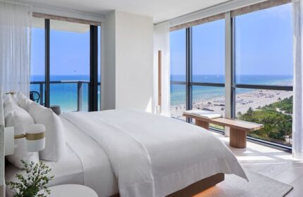 W South Beach gay-friendly hotel room view. Oceanfront suite with a king bed, floor-to-ceiling windows, and beach view. Luxury gay travel.