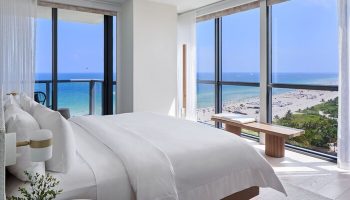 W South Beach gay-friendly hotel room view. Oceanfront suite with a king bed, floor-to-ceiling windows, and beach view. Luxury gay travel.
