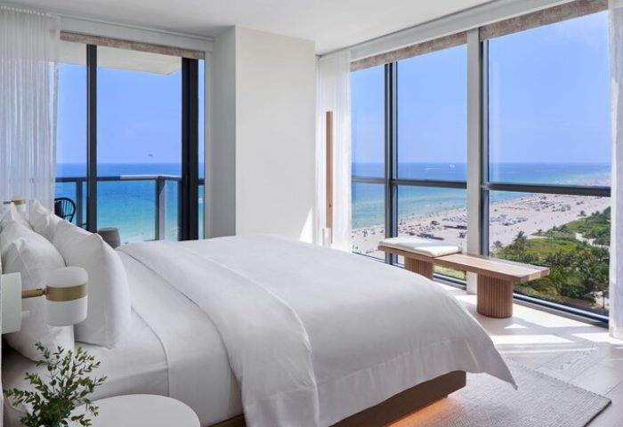 W South Beach gay-friendly hotel room view. Oceanfront suite with a king bed, floor-to-ceiling windows, and beach view. Luxury gay travel.