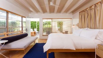 The Standard Miami gay-friendly hotel room. Modern decor, king bed, daybed, blue rug, and outdoor access. Perfect for gay travel.