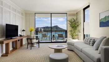 Halekulani Hotel's gay-friendly room with Diamond Head view. Balcony, seating, and elegant interior design. A luxury experience for gay travelers.