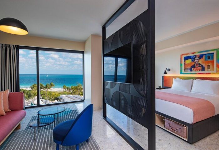 Moxy Miami South Beach gay-friendly hotel room. Ocean view, chic decor, TV partition, and a Frida Kahlo painting. Modern design.
