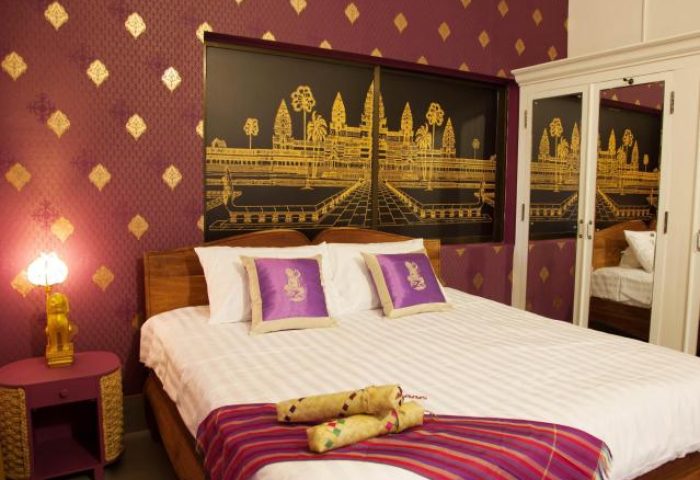 3 Monkeys Villa gay hotel room. Pet-friendly gay hotel with purple decor, gold accents, and a king-size bed. Gay travel lodging.