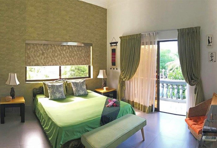 3 Monkeys Villa gay hotel bedroom with balcony. Pet-friendly gay-friendly hotel room interior. Gay men travel lodging.