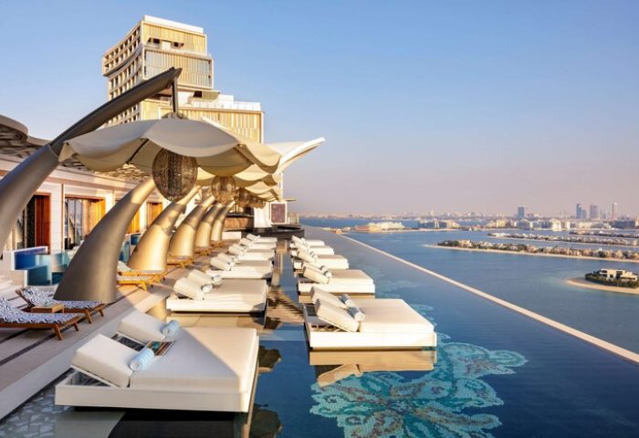 Atlantis The Royal gay-friendly hotel infinity pool view. Luxury travel for gay men. Dubai hotel with sunbeds and ocean view.