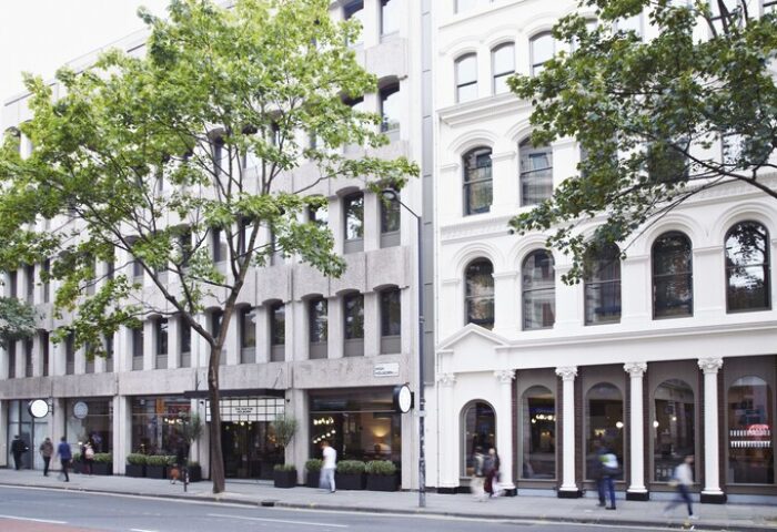 The Hoxton, Holborn: Gay-friendly hotel exterior. Modern and classic architecture. Street view with trees and pedestrians. London travel for gay men.