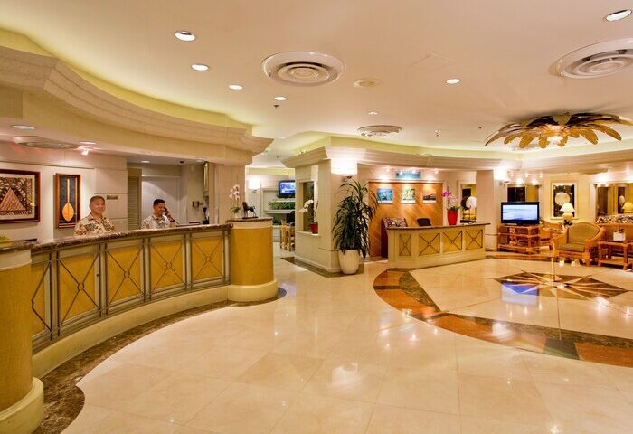 Ramada Plaza by Wyndham Waikiki lobby. Gay-friendly hotel with reception desk, marble floors, and seating area. Welcoming space for gay travelers.