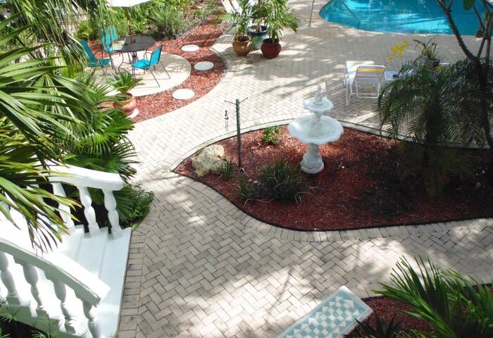 Cheston House, a gay-friendly hotel. View of the clothing optional all-male guesthouse, pool, garden, and patio. A tropical gay travel destination.