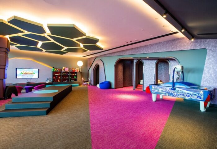 W Dubai - The Palm, gay-friendly hotel kids' club. Play area with air hockey, TV, toys, and colorful decor. A fun space for children.