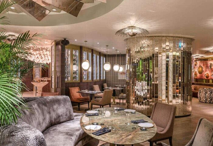 Raffles Istanbul Hotel's gay-friendly restaurant. The luxury dining area features stylish decor, elegant tables, and a mirrored accent wall.