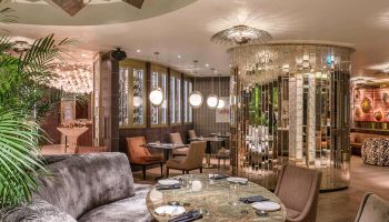 Raffles Istanbul Hotel's gay-friendly restaurant. The luxury dining area features stylish decor, elegant tables, and a mirrored accent wall.