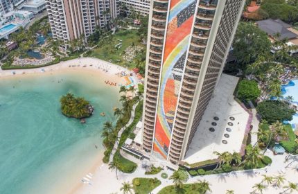 Hilton Hawaiian Village Waikiki Beach Resort aerial view. Gay-friendly hotel with beach, lagoon, and colorful tower. Perfect for gay men travel.