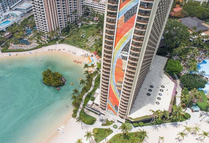 Hilton Hawaiian Village Waikiki Beach Resort aerial view. Gay-friendly hotel with beach, lagoon, and colorful tower. Perfect for gay men travel.