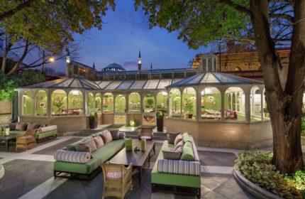 Hagia Sofia Mansions Istanbul, Curio Collection by Hilton gay-friendly hotel. Outdoor seating area at night with a view of the city.