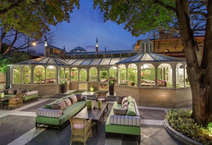 Hagia Sofia Mansions Istanbul, Curio Collection by Hilton gay-friendly hotel. Outdoor seating area at night with a view of the city.