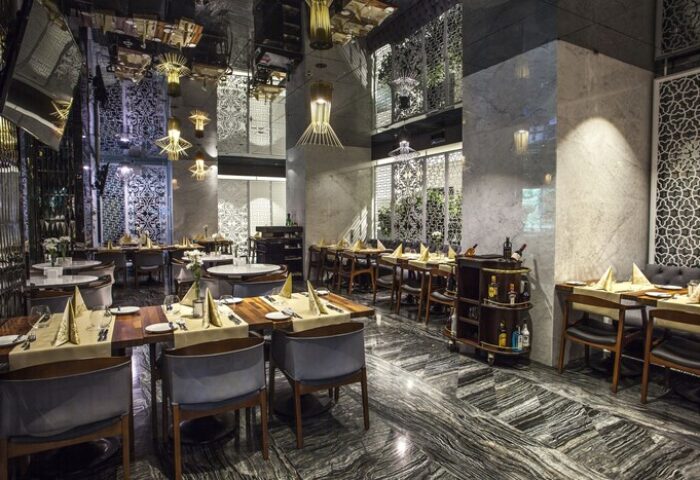 The Elysium Taksim Hotel's gay-friendly restaurant. Upscale dining area with set tables, mirrored ceiling, and marble accents. Ideal for gay travel.