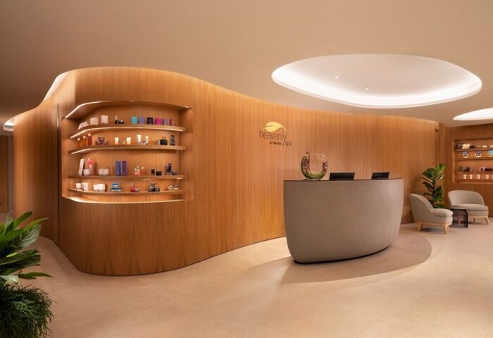 The Westin London City's spa reception area. Curved wood panels, product shelves, and a sleek desk create a modern, relaxing atmosphere. Gay-friendly hotel.