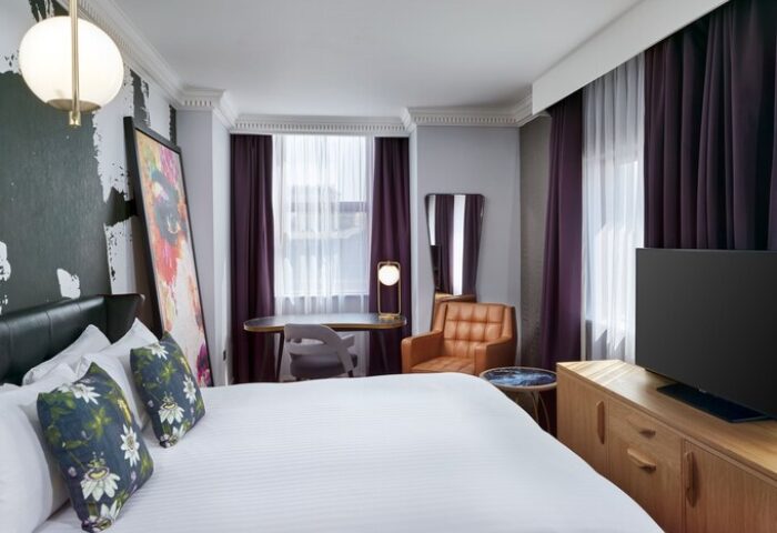 NYX Hotel London Holborn gay-friendly room. Modern design, desk, chair, and leather armchair. Comfortable stay for gay travelers.
