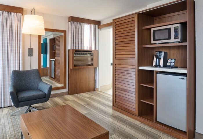 Holiday Inn Express Waikiki gay-friendly hotel room. Features include a chair, coffee table, mini fridge, microwave, and coffee maker.
