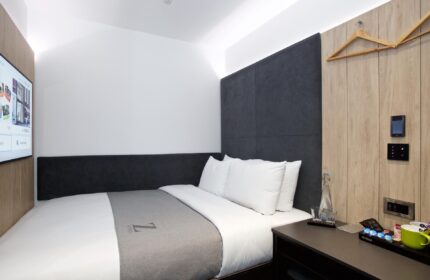 The Z Hotel Covent Garden room. Modern, compact design. Gay-friendly hotel with double bed, TV, and bedside table. Perfect for gay travel in London.