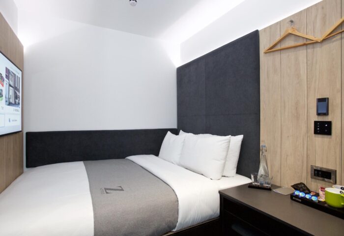 The Z Hotel Covent Garden room. Modern, compact design. Gay-friendly hotel with double bed, TV, and bedside table. Perfect for gay travel in London.