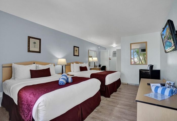 Hotel room at gay-friendly The Grand Resort and Spa. Two beds, modern decor, TV, and amenities. All-male spa resort accommodations.