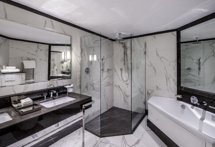 Fairmont St Andrews, Scotland gay-friendly hotel: Luxurious bathroom with marble walls, glass shower, double sink, and bathtub. Upscale travel.
