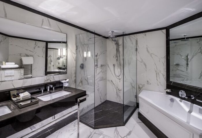 Fairmont St Andrews, Scotland gay-friendly hotel: Luxurious bathroom with marble walls, glass shower, double sink, and bathtub. Upscale travel.