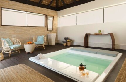 Sofitel Dubai The Palm Resort & Spa's relaxing spa area. Gay-friendly hotel with pool, seating, tea service, and serene decor. Ideal for gay travel.