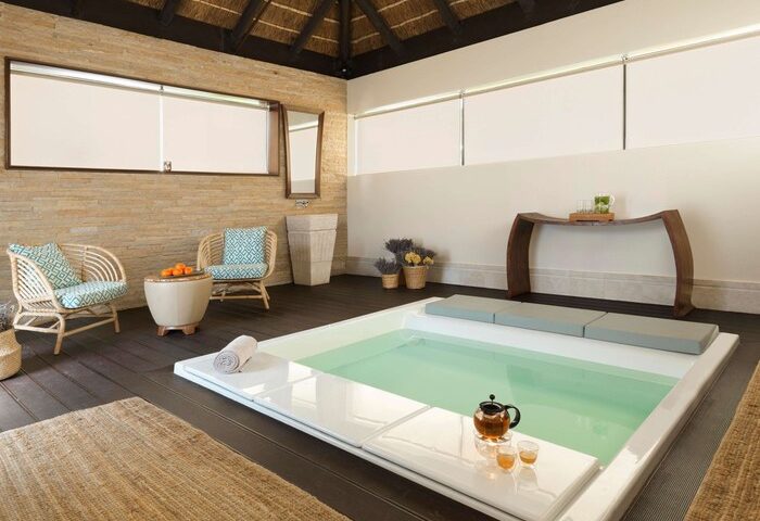 Sofitel Dubai The Palm Resort & Spa's relaxing spa area. Gay-friendly hotel with pool, seating, tea service, and serene decor. Ideal for gay travel.