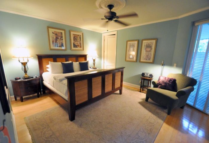 Pineapple Point Guesthouse bedroom. Gay-friendly hotel room with bed, chair, and ceiling fan. A relaxing space at the gay mens resort.