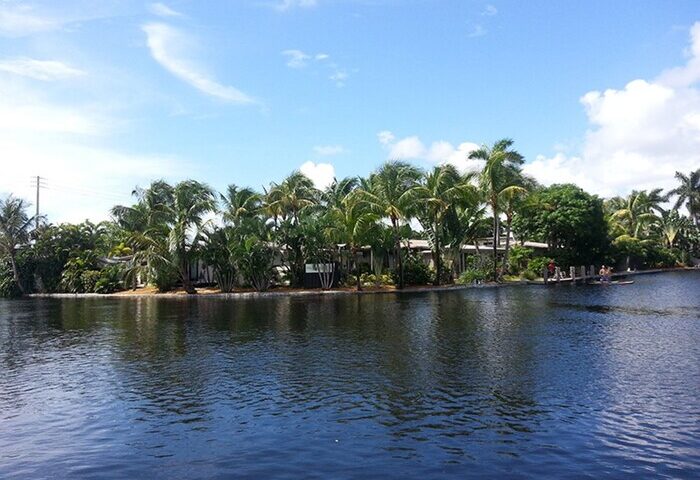 The Cabanas Guesthouse & Spa, a gay-friendly resort. Waterfront view with palm trees. A relaxing gay men's travel destination.